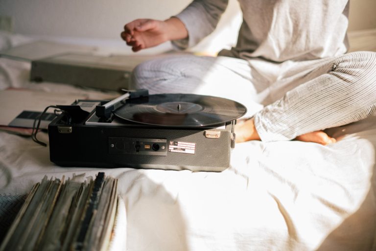 person in white long sleeve shirt in front of vinyl record